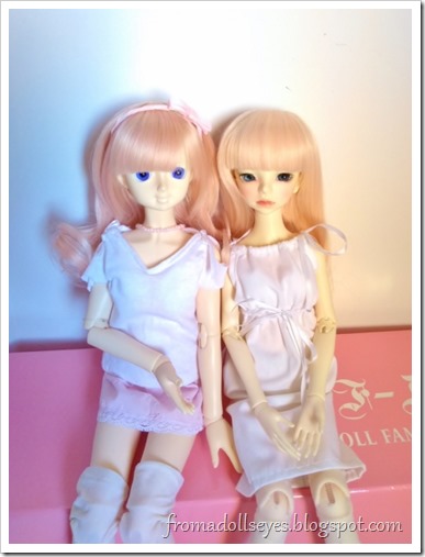 Two cute ball jointed dolls sitting together.