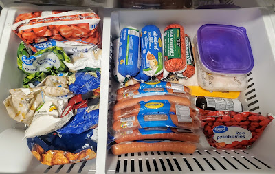 freezer drawer full of a variety of frozen fruits and vegetables and frozen meat