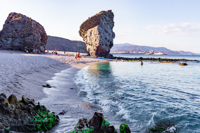 Playa con un portal formado por dos grandes rocas sobre la arena