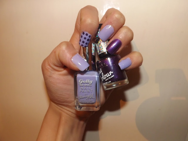 Hand holding purple nail polishes