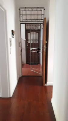 TILED PASSAGE LEADING TO FRONT DOOR WITH SECUIRITY GATES