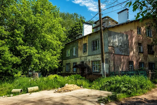 Пошарпанный дом на фоне густых деревьев