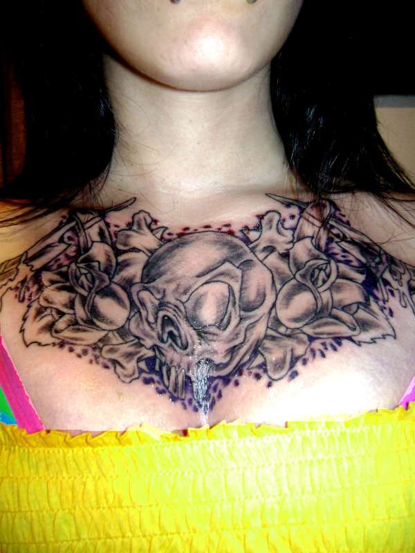 Skull and crossbones chest tattoo.