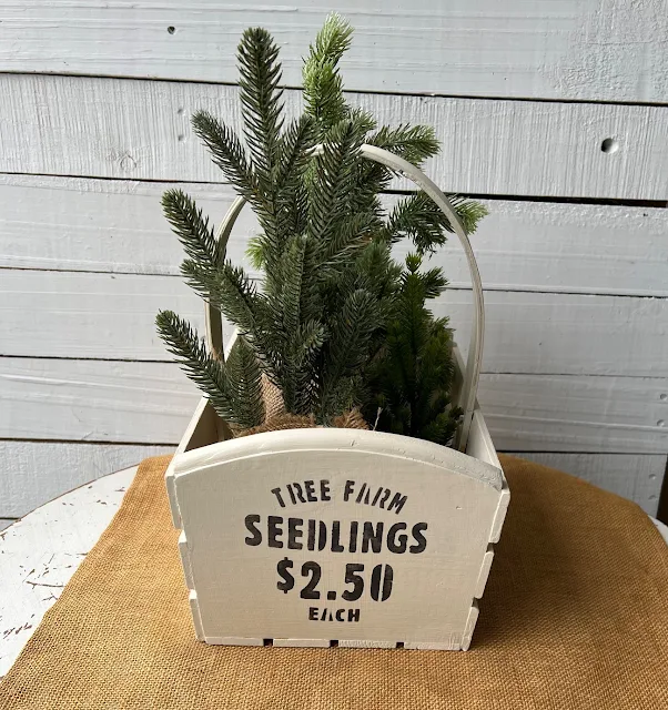 Photo of a stenciled wooden seedling basket with faux trees inside.