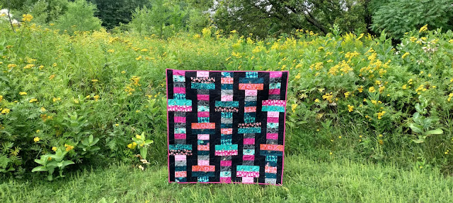 The Firefly collection sewn into a lap quilt using the Slice jelly roll pattern from Fat Quarter Shop