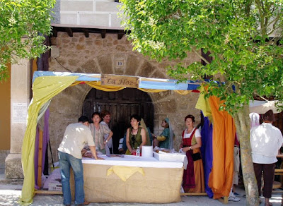 Puesto de rosquillas en mercado medieval con mujeres ataviadas a la antigua