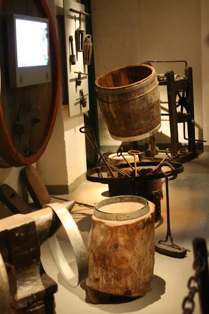 Two medium size wooden barrels amongst wooden equipment displays, in Carlberg Brewery, Copenhagen, Denmark.