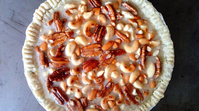 an unbaked nut pie sitting on a rustic baking sheet