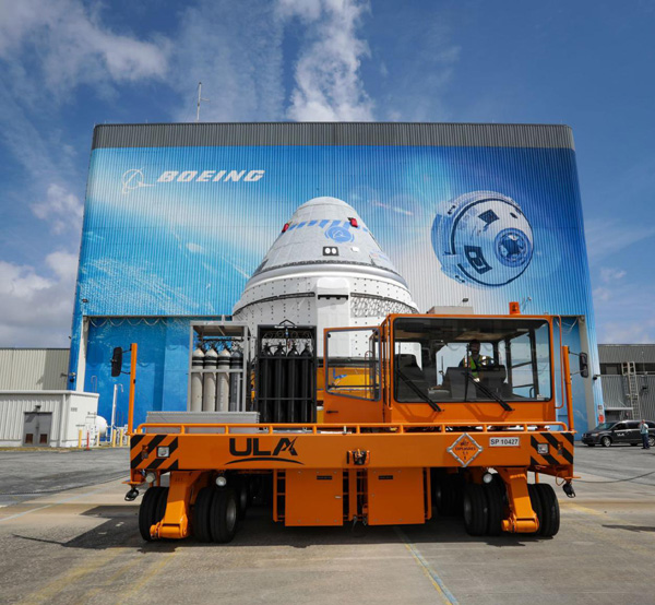 The transporter carrying Boeing's CST-100 Starliner capsule is about to roll away from the company's Commercial Crew and Cargo Processing Facility at NASA's Kennedy Space Center in Florida...on May 4, 2022.