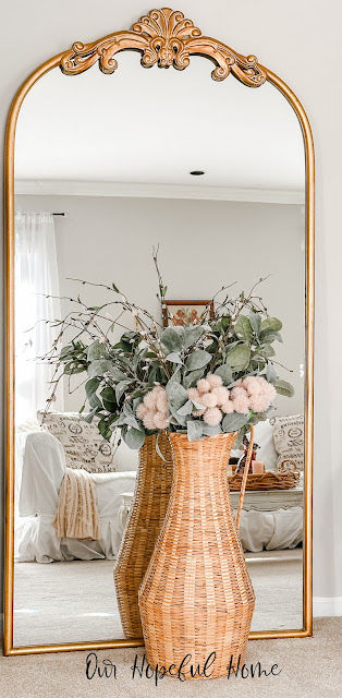 large gold mirror basket filled with flowers