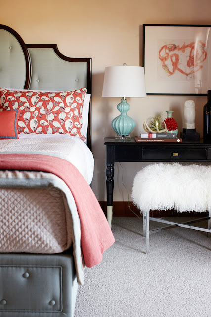 close up of nightstand with blue lamp with white shade and shag ottoman stool