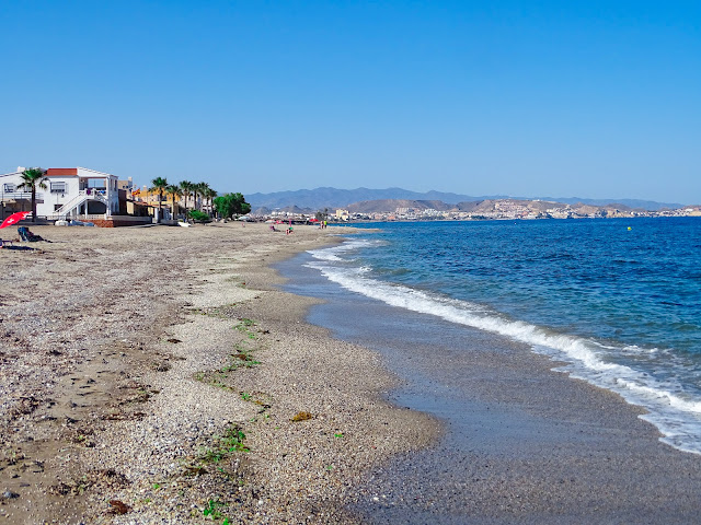 Playa de arena con las azules aguas del mar a su frente