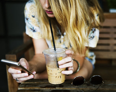 Chica utilizando una aplicación y tomando un smoothie