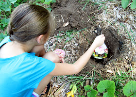 Tessa helped bury a mesh sack full of vegetable and fruit scraps in an empty plot in the garden. We'll check back in three months to see what happens when plants decay.