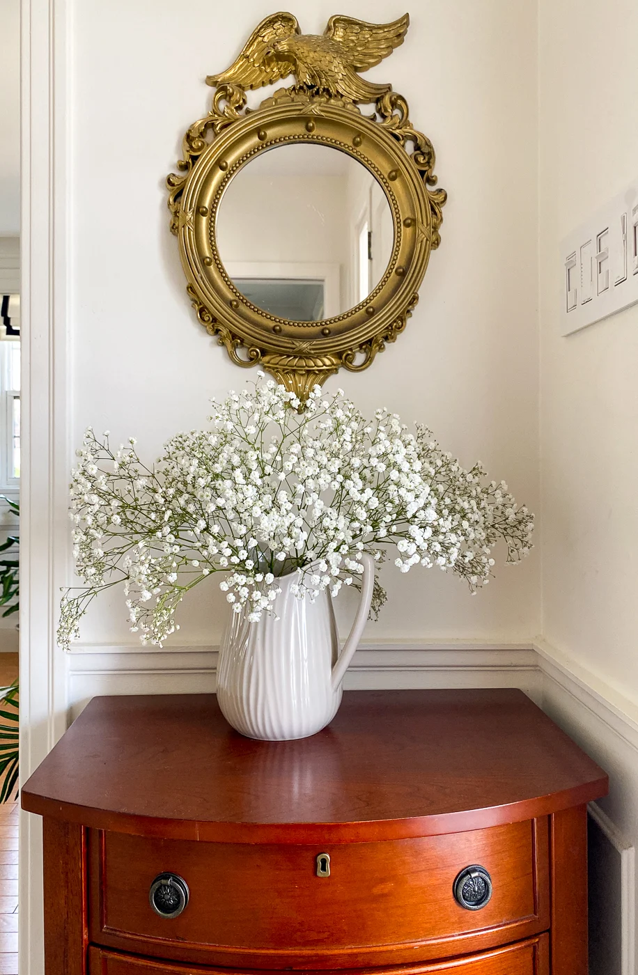 entryway cabinet with federal mirror and flowers in vase