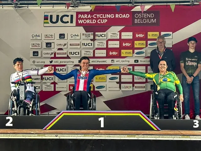 Pódio da prova de Gilmara com as atletas de mãos dadas enquanto estão sentadas nas suas cadeiras de rodas