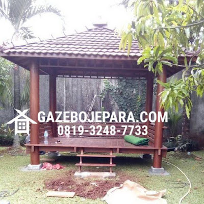 Gazebo model minimalis berukuran 3 Meter x 2 Meter yang berbahankan kayu pohon kelapa/ Glugu dengan ornamen saka bulat berdiameter D : 20 Cm yang kokok menopang atapnya, Model pagar garis lurus yang simple dan minimalis, Model atap genteng minimalis model genteng sirap model lancip dan kerpus dan mahkota juga menyerasikannya sangat cocok untuk taman rumah anda.