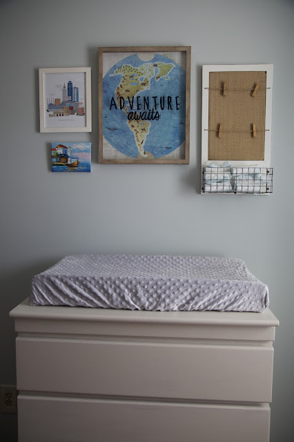 A travel and adventure-inspired gender neutral nursery with pops of pale gray, white, blue, and green.