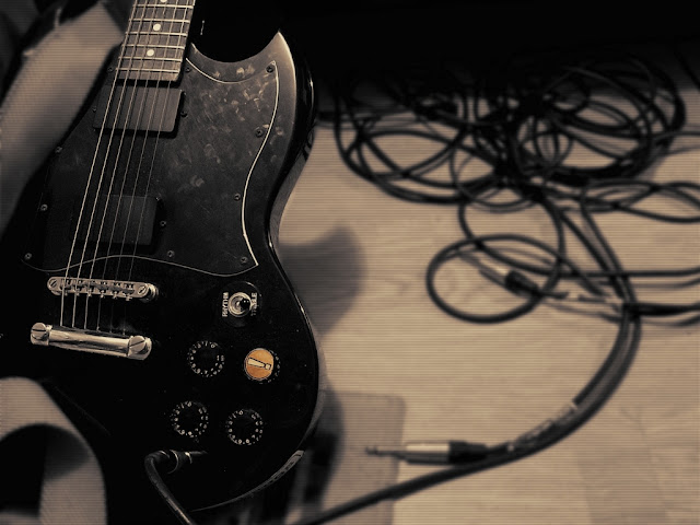 Black Electric Guitar Standing on Floor