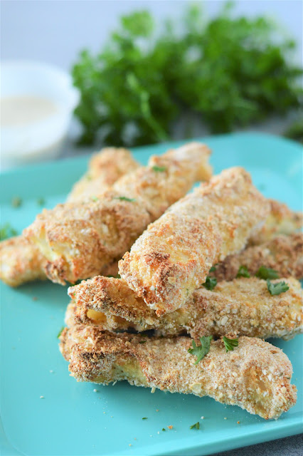 pile of fish sticks on a light blue plate.