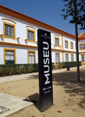 fachada de um edifício branco e uma placa de museu