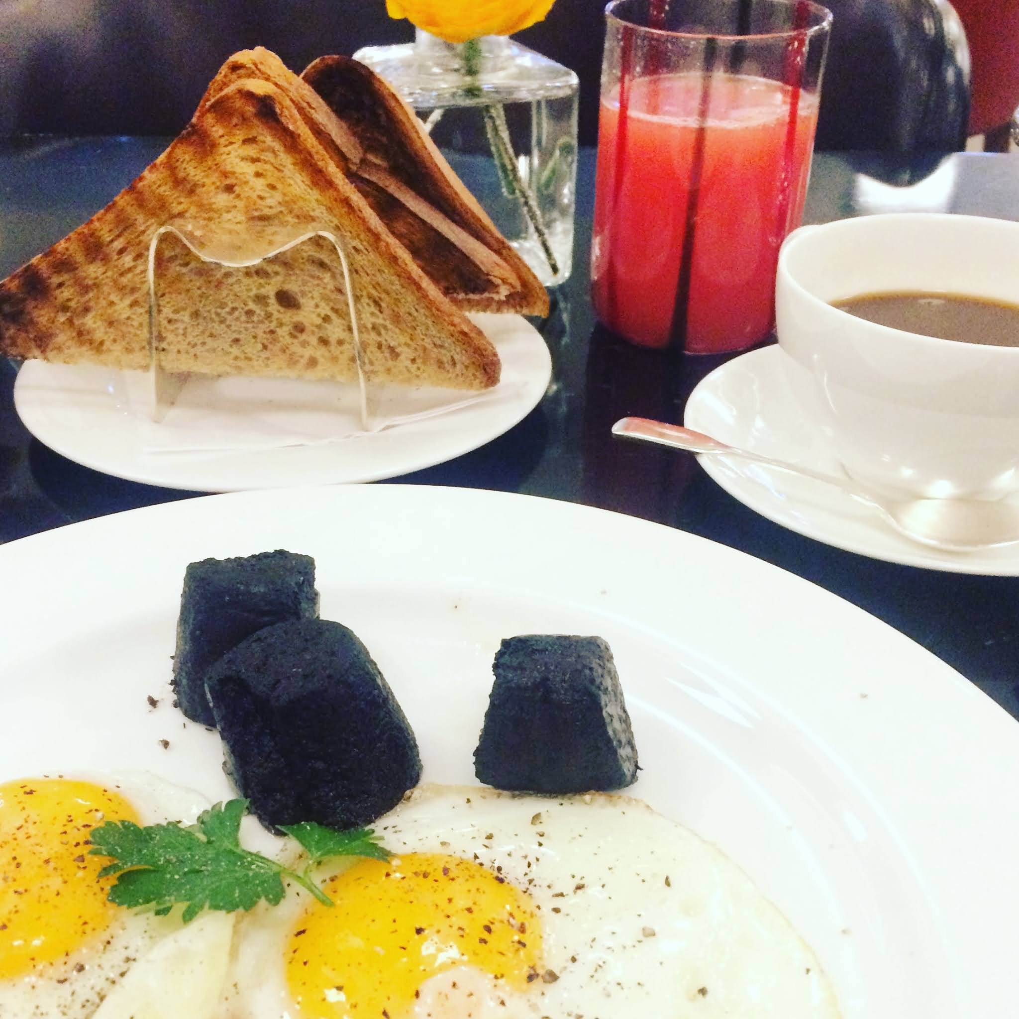 A plate of Fried eggs and black pudding at Hotel Cafe Royal, one of the best places for an early breakfast in london