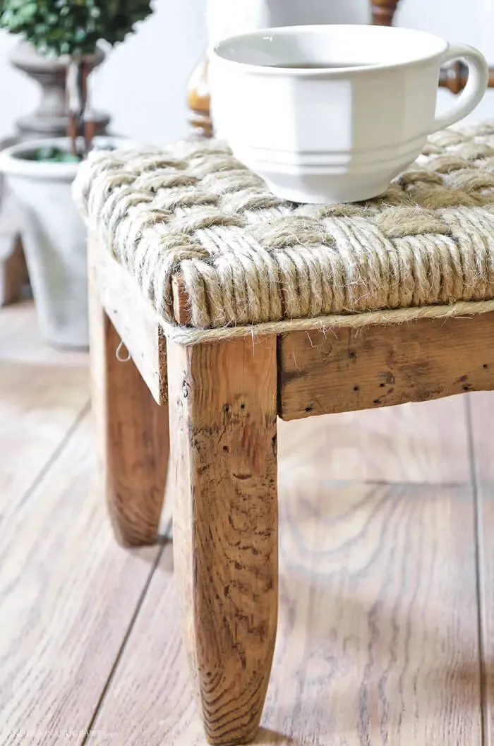 Side of wood footstool with woven top