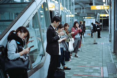 Fotografia [1] Homens e mulheres utilizando seus celulares