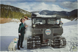 bride and groom kissing by snowcat