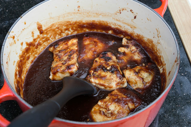 The grilled bbq chicken in the pot of sauce.