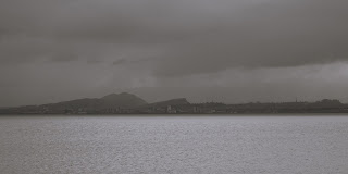 A photo showing a very grey scene over the Firth of Forth from Tickleness Point in Fife looking towards Edinburgh.  The hills of Edinburgh can be seen in silhouette.  Photograph by Kevin Nosferatu for the Skulferatu Project.