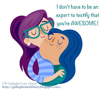 Woman in glasses embracing a woman with blue hair embracing her back.