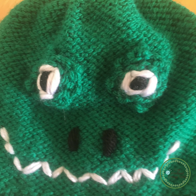 Close up of the face on the knitted crocodile beanie