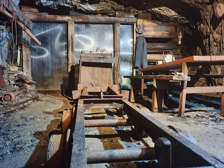 A picture containing wooden, chair, old, wood, inside the gold mine