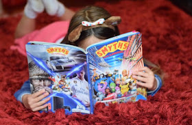 Child reading Smyths Toys Superstores catalogue