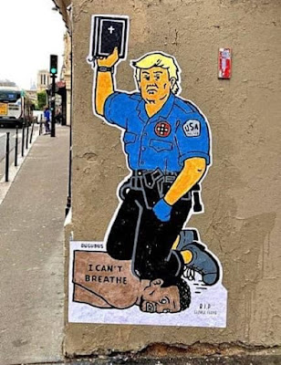 Trump kneeling on George Floyd's Neck holding a Bible painting on a wall in Europe