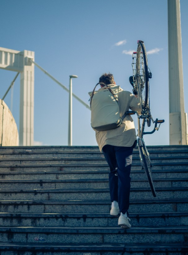 A salesperson who happens to be a kegler is carrying her bicycle to avoid the pitfall along the way