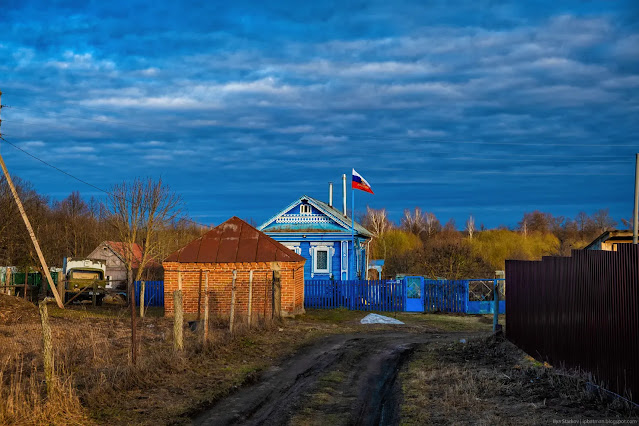 Синий деревянный дом с флагом России