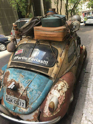 Fusca enferrujado cheio de malas.