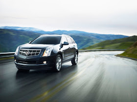 Front 3/4 view of 2011 Cadillac SRX on wet winding road