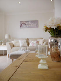 Before and after pictures showing how we transformed our dingy, small brightly-coloured lounge into a bright and airy living room using neutral coloured paint and accessories 