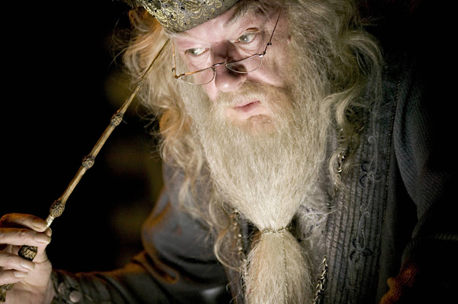Dumbledore is pointing the wand to his head.