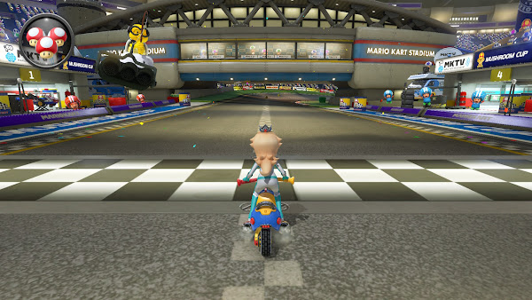 Screen Shot - Mario Kart 8: Deluxe - Rosalina riding a bike on the starting line of a time trial with various toads cheering her on.