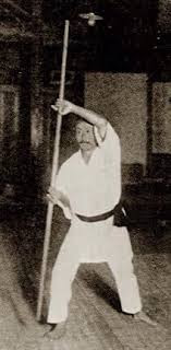 Gichin Funakoshi performing bōjutsu kata