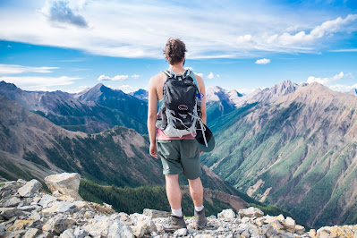 a man standing and wearing a backpack