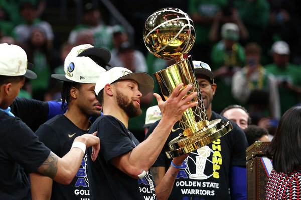 Steph Curry hoists the Larry O'Brien Trophy after the Golden State Warriors defeated the Boston Celtics, 103-90 in Game 6 of the NBA Finals, to win their fourth championship in seven years...on June 16, 2022.