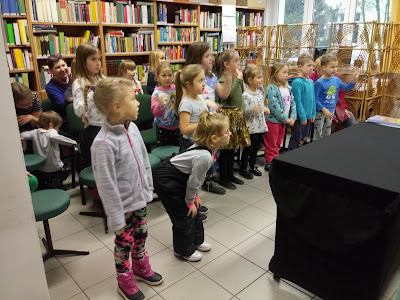 Na zdjęciu dzieci- widzowie ćwiczą tak jak pokazują aktorzy