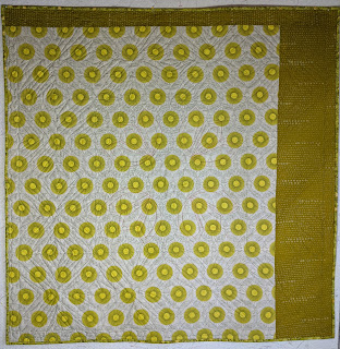 Two chartreuse prints make the back of this quilt