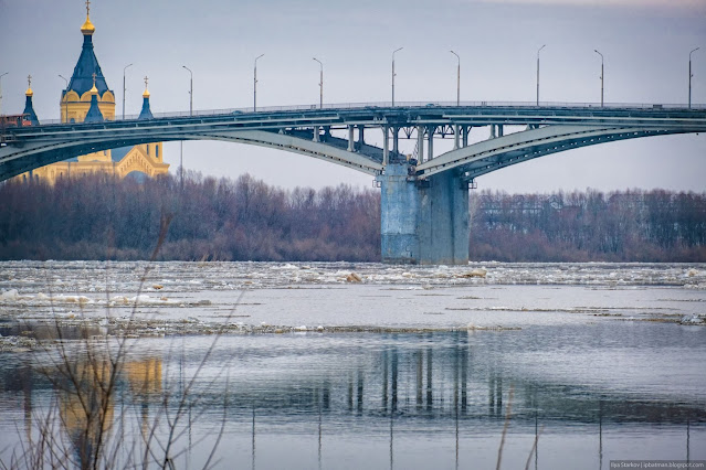 Ледоход на реке под мостом на фоне Собора Александра Невского