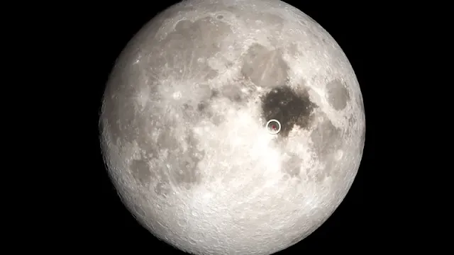The darkened mare basin is the Sea of Tranquility, site of the Apollo 11 landing (white circle), NASA's first human mission to the Moon. The red dot marks the approximate landing site.